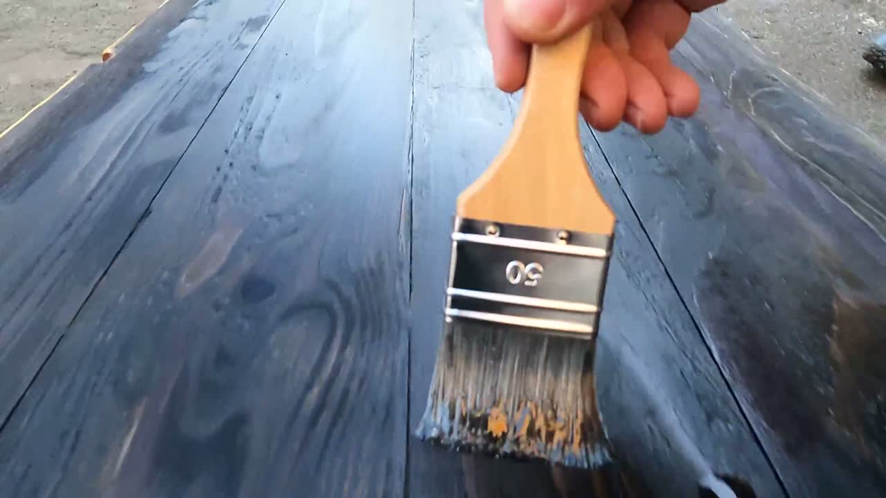 Lasur wird mit dem Pinsel ins Holz gezogen
